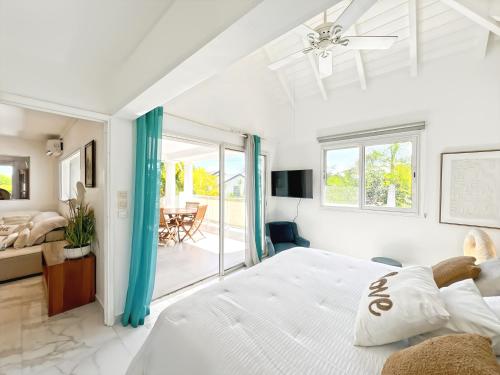 ein weißes Schlafzimmer mit einem Bett und einem Esszimmer in der Unterkunft Villa Mangorient 3 bd private pool in Orient Bay in Orient Bay