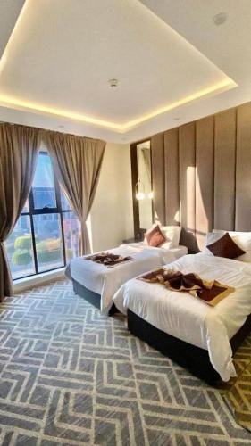 Una habitación de hotel con dos camas y una ventana. en اوبن هوسبتالتي ابها Open, en Abha
