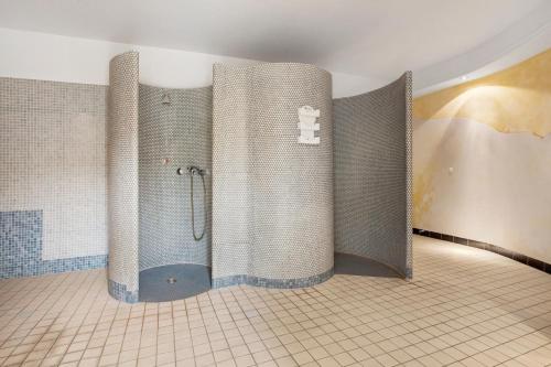 een douche in een badkamer met een betegelde muur bij Villa Sonneck Appartement 20 in Ostseebad Sellin