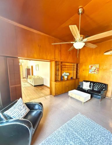 un soggiorno con mobili in pelle e ventilatore a soffitto di Lafayette Family Home-Free Parking Downtown & 3 Bedrooms a Lafayette