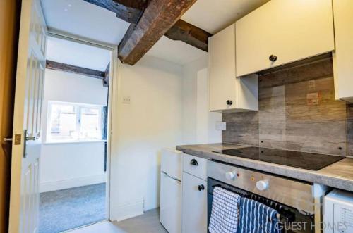a kitchen with a stove top oven next to a door at Charming 2-Bed Apartment in Bewdley Town Centre in Bewdley