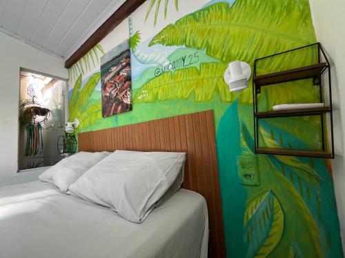 a bedroom with a bed with a colorful wall at Casa Guarnicê Hostel in São Luís