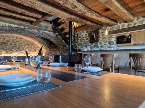 a dining room with a long wooden table with wine glasses at Buron de Léon, en plein cœur de l Aubrac in Laguiole