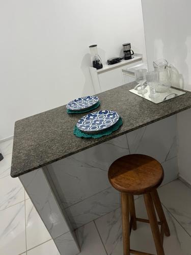 卡诺格布拉达Apartamento da Kenia的厨房台面上放着两个盘子和一张凳子