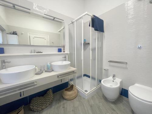 Villa Atusca - Castiglioncello في كاستجليونسيلو: حمام أبيض مع مغسلتين ودش