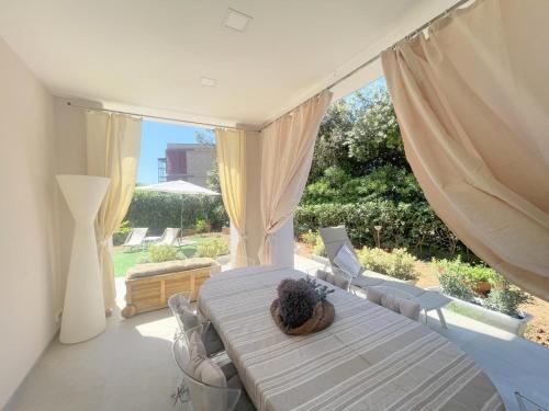 Villa Atusca - Castiglioncello في كاستجليونسيلو: غرفة نوم بها سرير ونافذة كبيرة