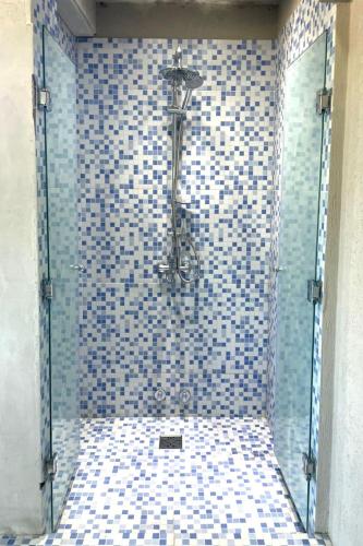 a shower with a blue and white tiled wall at Jade Residencias de Mar in Villa Gesell