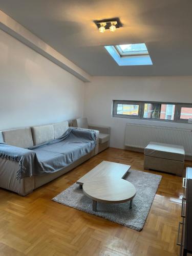 una sala de estar con un sofá y una mesa en Apartman Luka, en Niš