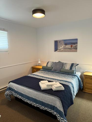 a bedroom with a bed with two towels on it at Bleuzen chalet entier in Petite-Rivière-Saint-François
