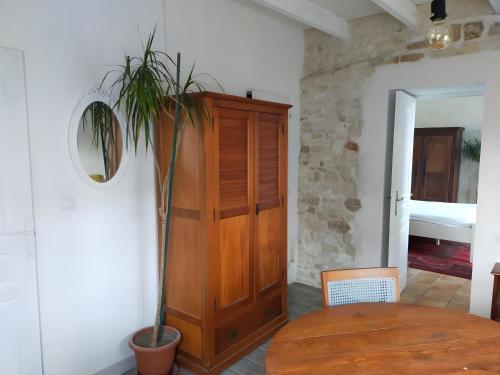 une pièce avec une armoire en bois et une table avec une plante dans l'établissement Gite La Maison d'Harmonie, à Bourgneuf