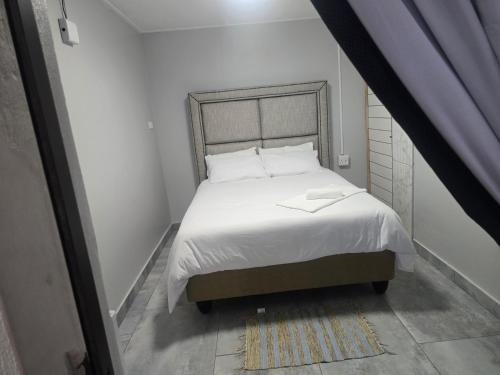 una camera da letto con un letto con lenzuola bianche e cuscini bianchi di Cooperville a New Germany