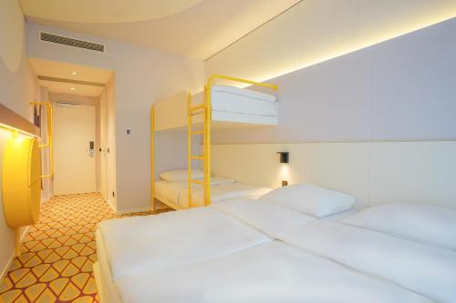 オスナブリュックにあるPrize by Radisson, Osnabruckのベッドルーム1室(二段ベッド2組付)、廊下が備わります。