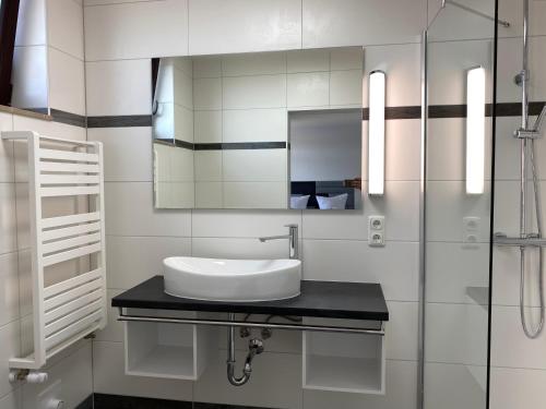 une salle de bain blanche avec un lavabo et un miroir dans l'établissement Hotel & Restaurant Deutsches Haus Feldberg, à Feldberg