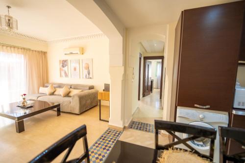 una sala de estar con un sofá y una mesa en Luxury 2 BDRM in Hivernage with Pool and Garden, en Marrakech