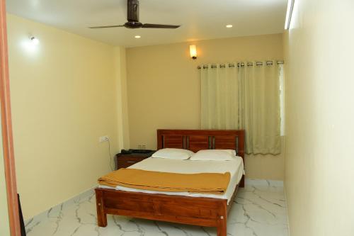 een slaapkamer met een bed en een plafondventilator bij Sri KASTHURI Residency in Tiruttani
