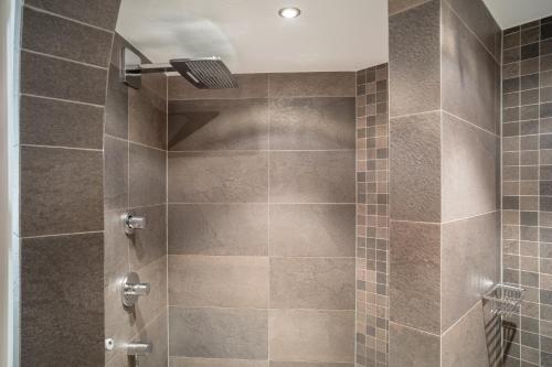 a bathroom with a shower with brown tile at Alpenresidenz am Mühlbach in Obergurgl
