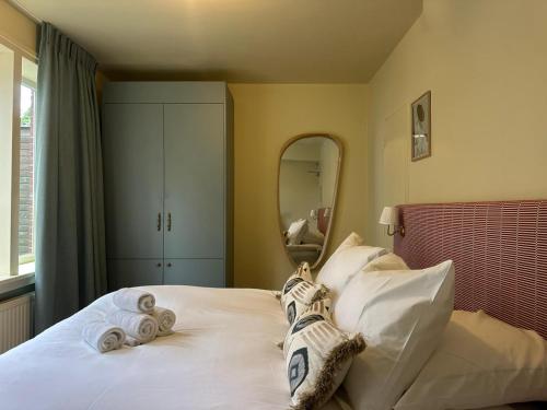 a bedroom with towels on a bed with a mirror at Hotel Atlas Vondelpark in Amsterdam