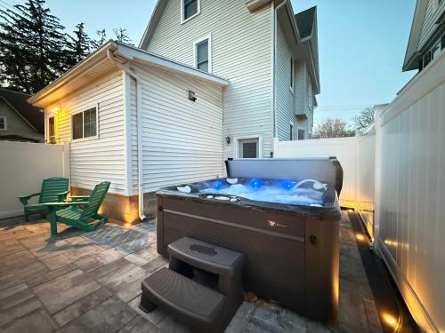 a hot tub on a patio next to a house at Heron Hideaway Game Room within walking distance to HWS & Seneca Lake in Geneva