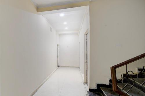 a hallway with a white wall and a door at SPOT ON The Royal Inn in Kakarmatha