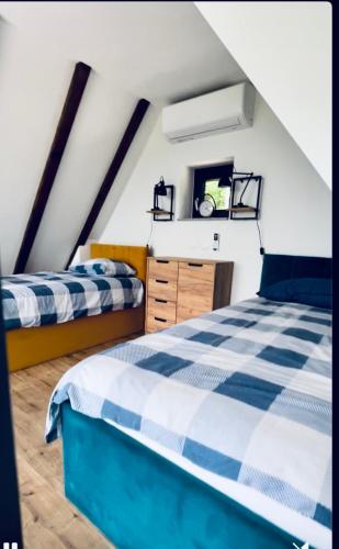 a attic bedroom with two beds and a dresser at Melody in Kapela