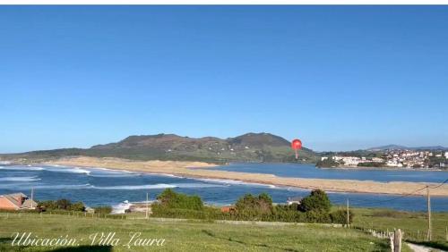 ein Strand mit einem roten Ballon im Wasser in der Unterkunft Villa Laura in Boó de Piélagos