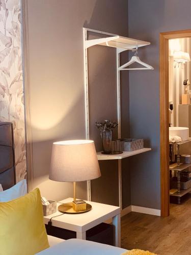 a lamp on a table in a room with a mirror at Largo da Rainha, Guesthouse in Merciana