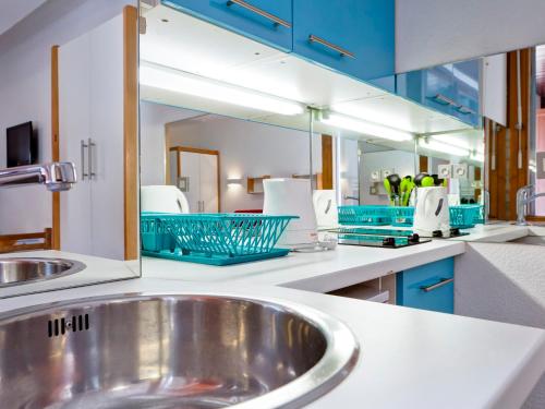 eine Küche mit einem Waschbecken und einem Spiegel in der Unterkunft Studio 2* Brides-les-Bains avec WIFI, 4 personnes - FR-1-512-141 in Brides-les-Bains