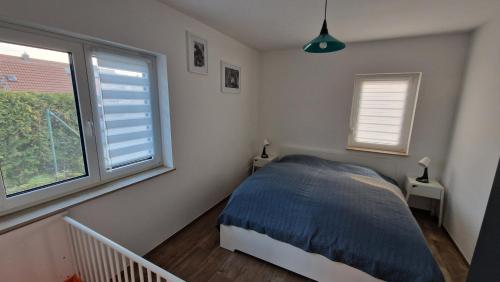 una camera da letto con un letto e due finestre di Ferienhaus Peitz a Peitz