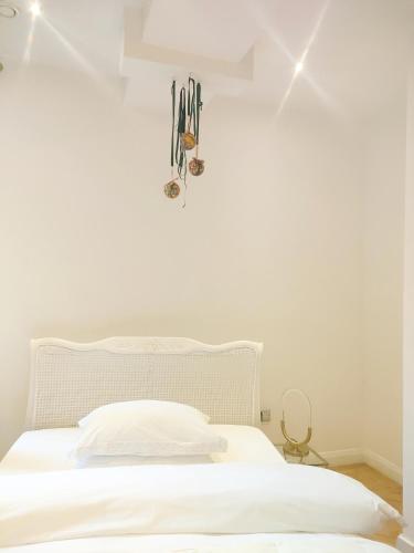 une chambre avec un lit blanc et des skis accrochés au mur dans l'établissement Versailles, à Nottingham