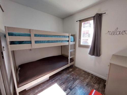 ein Schlafzimmer mit zwei Etagenbetten und einem Fenster in der Unterkunft Appartement familial 5 pers, centre-ville, Wifi - FR-1-512-210 in Brides-les-Bains