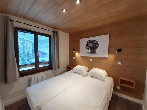 a bedroom with a white bed with a window at Moderne 3 pièces, balcon sud, centre station, pied des pistes – Courchevel - FR-1-513-23 in La Tania