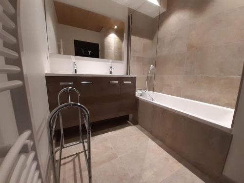 a bathroom with a tub and a sink and a mirror at Moderne 3 pièces, balcon sud, centre station, pied des pistes – Courchevel - FR-1-513-23 in La Tania