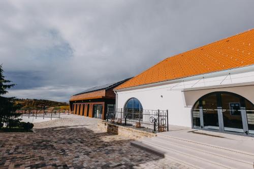un grand bâtiment blanc avec un toit orange dans l'établissement Wine & boutique hotel Terbotz, à Štrigova