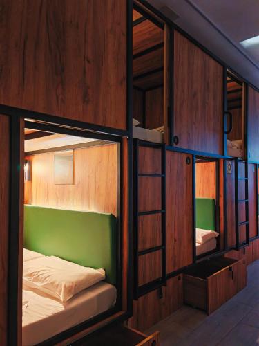two bunk beds in a room with wooden walls at Capsule Inn Madrid in Madrid