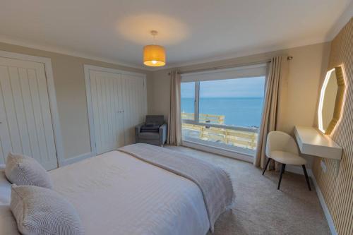 a bedroom with a bed and a view of the ocean at The View at Portpatrick. in Portpatrick