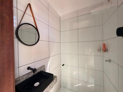 ein Badezimmer mit Waschbecken und Spiegel in der Unterkunft Pousada Villa Egregora in Itacimirim