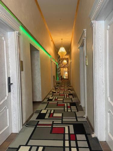 un couloir avec un sol carrelé et des lumières vertes dans l'établissement Siena Hotel, à Odessa