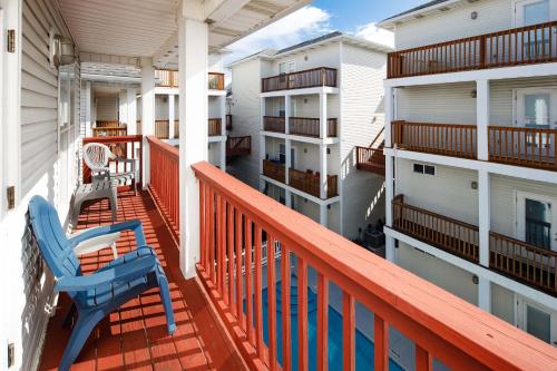 een terras met een blauwe stoel op een balkon bij Sunset Cottages 1C Pet friendly cottage in Fort Walton Beach