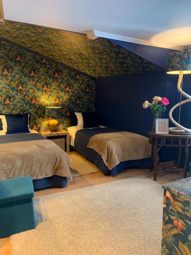 a bedroom with two beds and a wall mural at Largo da Rainha, Guesthouse in Merciana