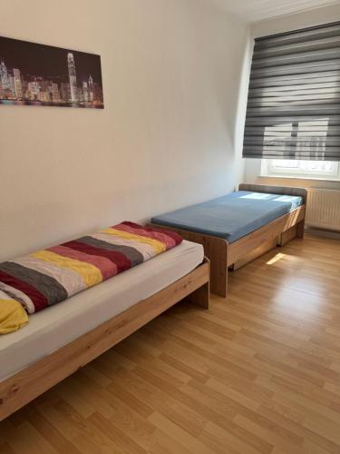 due letti in una stanza con una finestra di Gemütliche Praktische Wohnungen a Gera