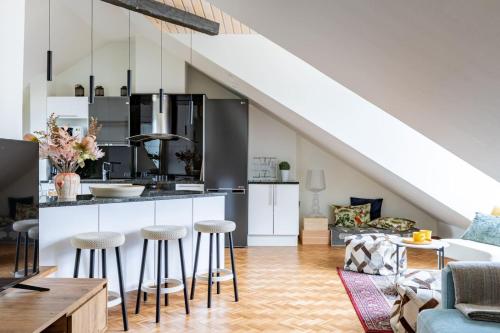 eine Küche mit Theke und Hockern in einem Wohnzimmer in der Unterkunft Scandi City Loft, Jacuzzi, Balcony, AirCon in Helsinki