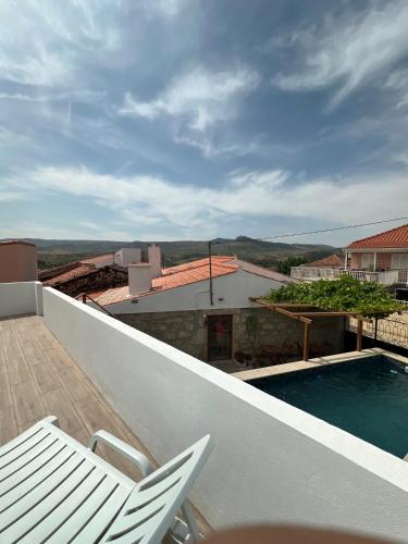 a balcony with a chair and a swimming pool at JUNKEIRA - Casa, Douro e Campo