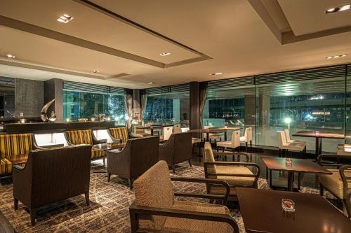 a restaurant with tables and chairs and windows at ANA Crowne Plaza Fukuoka by IHG in Fukuoka