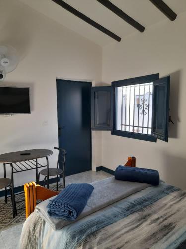 a bedroom with a bed and a table and a window at La Casita Perlita in Arboleas