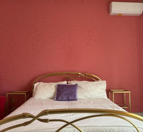 a bed with a gold frame and white pillows at Mariuccia Home in Siracusa