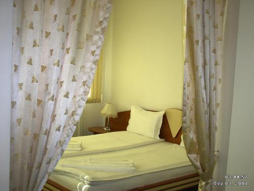 a bedroom with a bed with a canopy and curtains at hotel TEDI in Asenovgrad