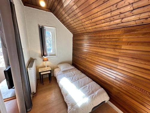 Zimmer mit einer Holzwand mit 2 Betten in der Unterkunft Charmant Duplex 55m² - Coeur de Villard-de-Lans, 5 pers, Terrasse, Proche Commerces et Loisirs - FR-1-515-208 in Villard-de-Lans