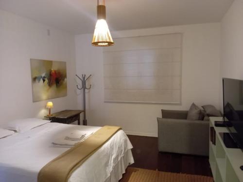 a bedroom with a bed and a couch and a light at Casa Prana in Bragança Paulista
