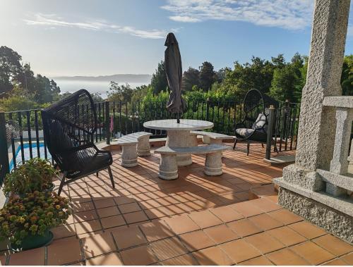 a patio with an umbrella and a table and chairs at El mirador de Monte Bouza in Monte Bouza