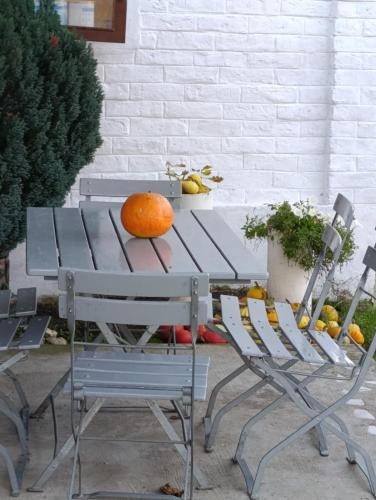 Eine Orange liegt auf einem Picknicktisch mit zwei Stühlen. in der Unterkunft Apartman Kepić in Sirova Katalena
